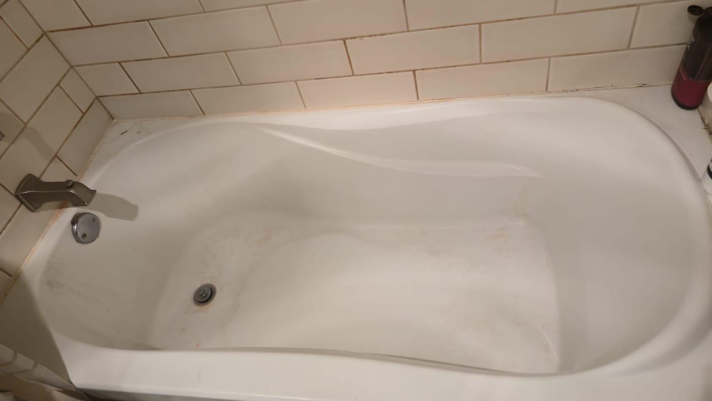 White bathtub scrubbed clean, with the tiled wall above