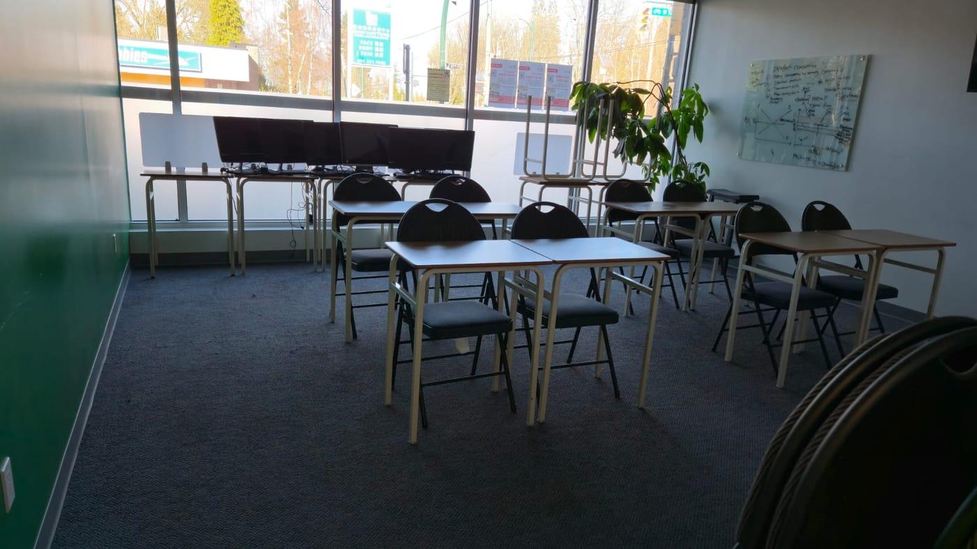 Bright classroom with tidy desks and chairs and freshly vacuumed carpet
