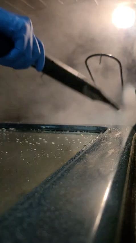 Steam wand lifting grime from a metal edge